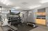 Modern gym with state-of-the-art equipment, sleek mirrors, and abundant towels for convenience and comfort.