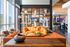 Modern and inviting lounge area with vibrant orange sofas, elegant decor, and floor-to-ceiling windows offering abundant natural light.