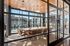 Elegant modern conference room with large glass walls, stylish wooden ceiling, and sophisticated lighting, offering a chic and inviting workspace.