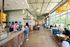 Bright, modern café with floor-to-ceiling windows, cozy seating, and a bustling atmosphere.