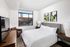 Bright bedroom with a cozy double bed, large window view, modern decor, and elegant furniture.
