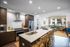 Modern open-concept kitchen and living space with sleek appliances, ample natural light, and stylish decor, overlooking a pool area.