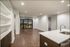 Elegant open-concept apartment with modern kitchen, hardwood floors, and city view balcony access.