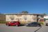 Charming two-story suburban apartment building with well-maintained facade and parked cars in front.