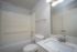 Contemporary bathroom with a pristine bathtub, elegant vanity, and modern lighting.