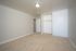 Bright and airy bedroom featuring beige carpet and a built-in closet.