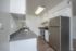 Contemporary kitchen with stainless steel appliances and grey countertops in a bright setting.