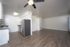 Modern apartment interior showcasing an open-concept kitchen with stainless steel appliances and spacious living area with wood flooring.
