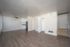 Bright open-concept living area with wood flooring, neutral walls, and modern kitchen.
