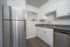 Contemporary kitchen with stainless steel appliances, white cabinetry, and modern sink.