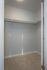 Bright, open walk-in closet with ample hanging space and soft carpet flooring.