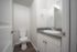 Chic bathroom with modern fixtures, featuring a stylish sink, sleek countertop, and a pristine toilet next to a large mirror.