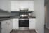 Contemporary kitchen with stainless steel appliances and white cabinetry.