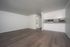 Bright, open living space featuring sleek hardwood floors and a modern kitchenette.