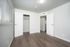 Bright and airy bedroom with elegant hardwood flooring, fresh white walls, and a spacious closet.