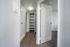 Bright hallway featuring elegant wood flooring and ample storage with open shelving, perfect for modern living.