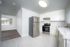 Sleek and modern kitchen with stainless steel appliances, elegant white cabinetry, and a stylish tile floor.