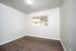Bright room featuring polished hardwood floors and a large window with blinds for natural light.