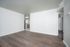 Chic and spacious living area with elegant hardwood floors and modern lighting, leading to a cozy kitchen with sleek appliances.