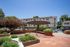 Inviting apartment complex courtyard featuring lush landscaping, a stylish pergola, and modern paved walkways, creating a peaceful outdoor retreat.