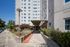 Charming apartment entrance surrounded by lush greenery and modern architecture, offering a serene urban living experience.