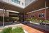 Charming apartment entrance with modern architecture, lush greenery, and welcoming pathways.