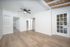 Bright, inviting room with modern wood flooring, a ceiling fan, and large glass double doors leading outside.