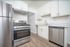 Modern kitchen with stainless steel appliances, sleek white cabinetry, and elegant marble countertops.