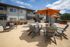 Charming apartment complex courtyard with inviting outdoor seating and vibrant orange umbrellas, perfect for relaxed gatherings.