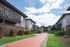 Charming apartment complex with lush landscaping, featuring well-maintained walkways and outdoor spaces under a bright blue sky.
