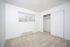 Bright bedroom with plush carpet, large window with vertical blinds, and spacious built-in closet.
