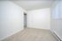 Brightly lit pristine room with soft carpet and a modern white door, creating a welcoming and serene atmosphere.
