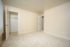 Bright, spacious room with fresh carpet and a large open closet, offering endless design possibilities for your dream home.