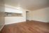 Bright open-concept living space with elegant hardwood floors and a cozy kitchen pass-through, perfect for modern living.