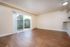 Bright and spacious living room with elegant wood flooring and expansive sliding glass doors leading to a private outdoor area.