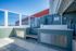 Bright and spacious rooftop area featuring modern outdoor cabinetry and stunning skyline views.