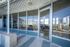 Modern apartment entrance with expansive glass windows, showcasing a bright and inviting interior with stylish seating arrangements.
