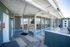 Modern rooftop access with sleek architectural design, featuring expansive glass windows and outdoor seating for relaxation.