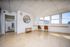 Bright and airy office space with modern seating, large windows, and sleek tile flooring.