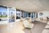 Bright and inviting lobby area with modern seating, large windows, and access to a sunlit outdoor terrace.
