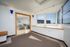 Bright and airy room with large windows, modern seating area, and a pass-through enclosed by light wood framing, perfect for relaxation and enjoying the view.