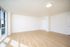 Bright and spacious empty room with hardwood flooring, large windows, and modern lighting, perfect for customizing your ideal living space.