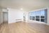 Bright, spacious living room with elegant hardwood floors and large windows offering panoramic views.