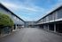 Inviting apartment complex with ample parking and modern exterior, set against a vibrant blue sky.