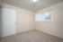 Bright, versatile room with neutral carpet and modern vertical blinds, perfect for customization.