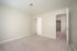Bright and spacious bedroom featuring plush carpet, neutral walls, and ample closet space with a sleek sliding door.