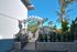 Charming gated entrance with elegant archway, lush greenery, and palm trees in a serene community setting.