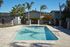 Inviting outdoor pool surrounded by lush greenery, perfect for relaxation and leisure in a serene residential setting.