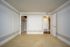 Bright and spacious room with elegant molding, plush carpet, and a walk-in closet offering ample storage space.