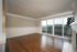 Bright and airy living space with elegant hardwood floors, large glass sliding doors leading to a scenic balcony.
